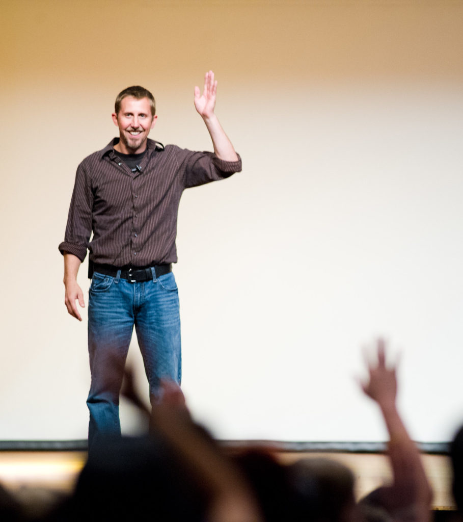 Man speaking to crowd on stage.