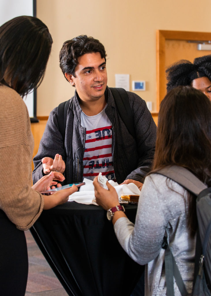 A group of students talking around a table.