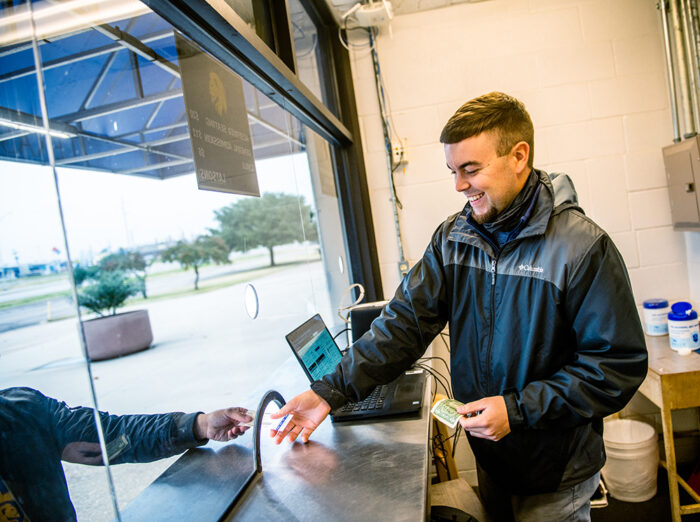 Student volunteering at a ticket booth for a football game.