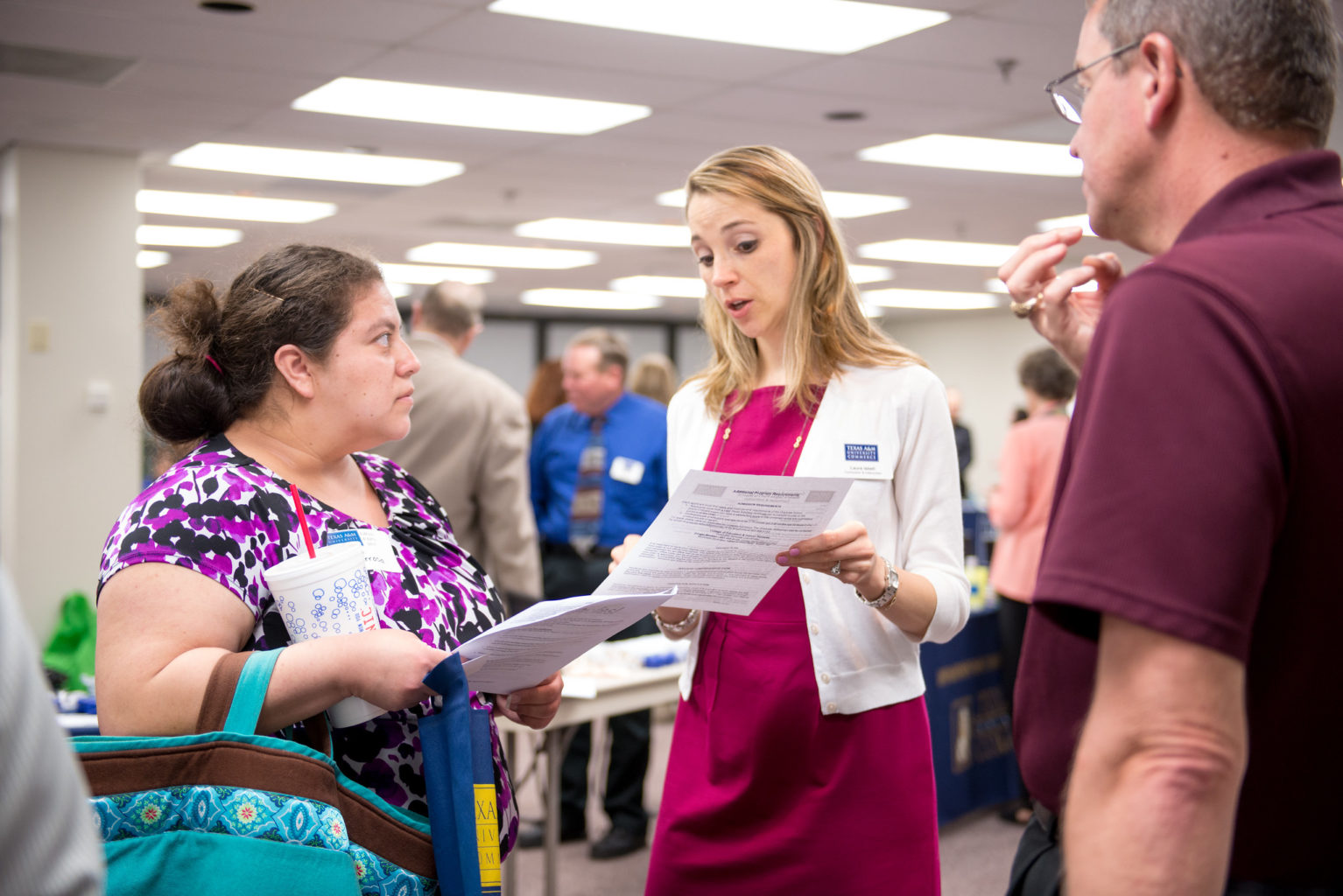 Two adult females conversing with papers in their hands