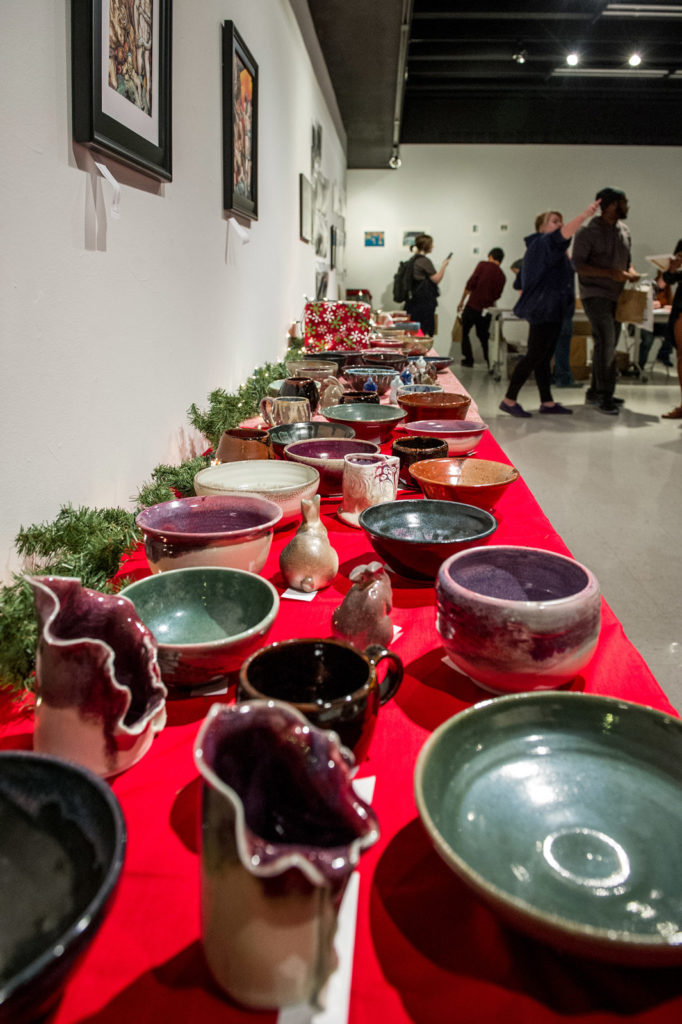 Ceramic art pieces on tables in art gallery.