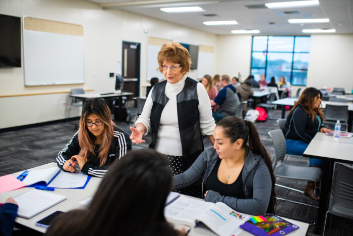 Faculty member working with college students in a large classroom