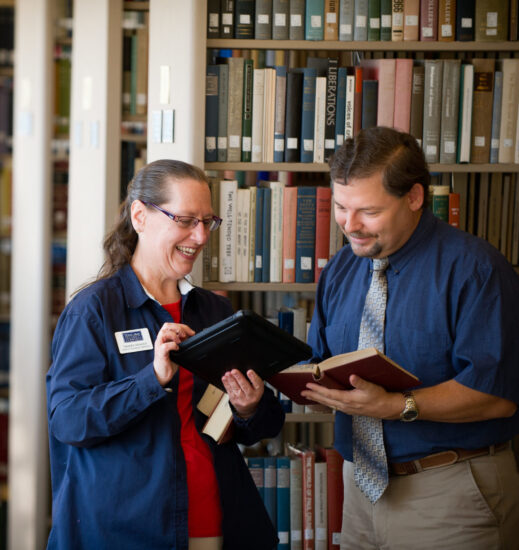 Two librarians standing in a library.