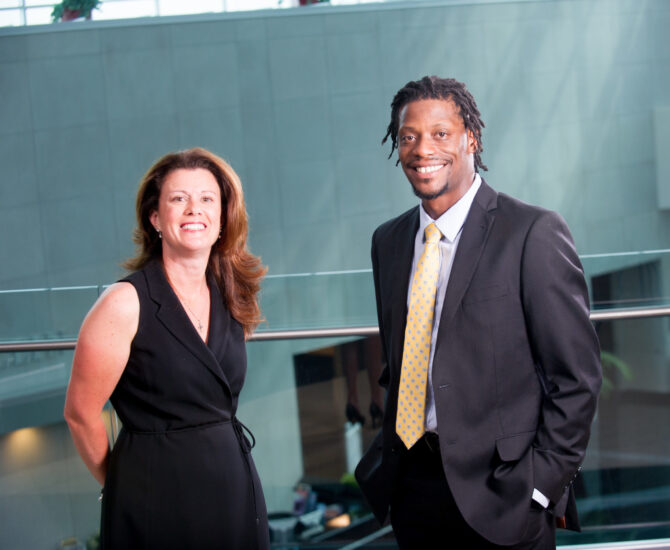 Two students professionally dressed smiling.