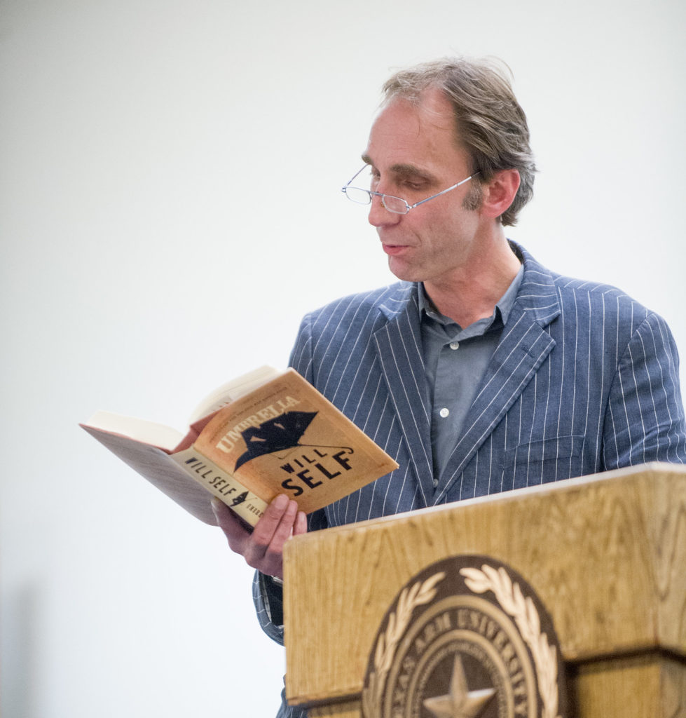 Man reading book from podium.