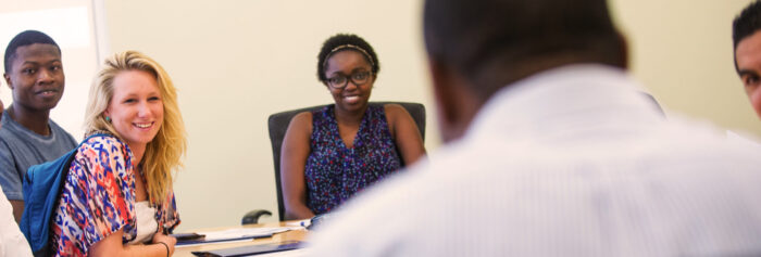 Student sitting around a conference room style table.