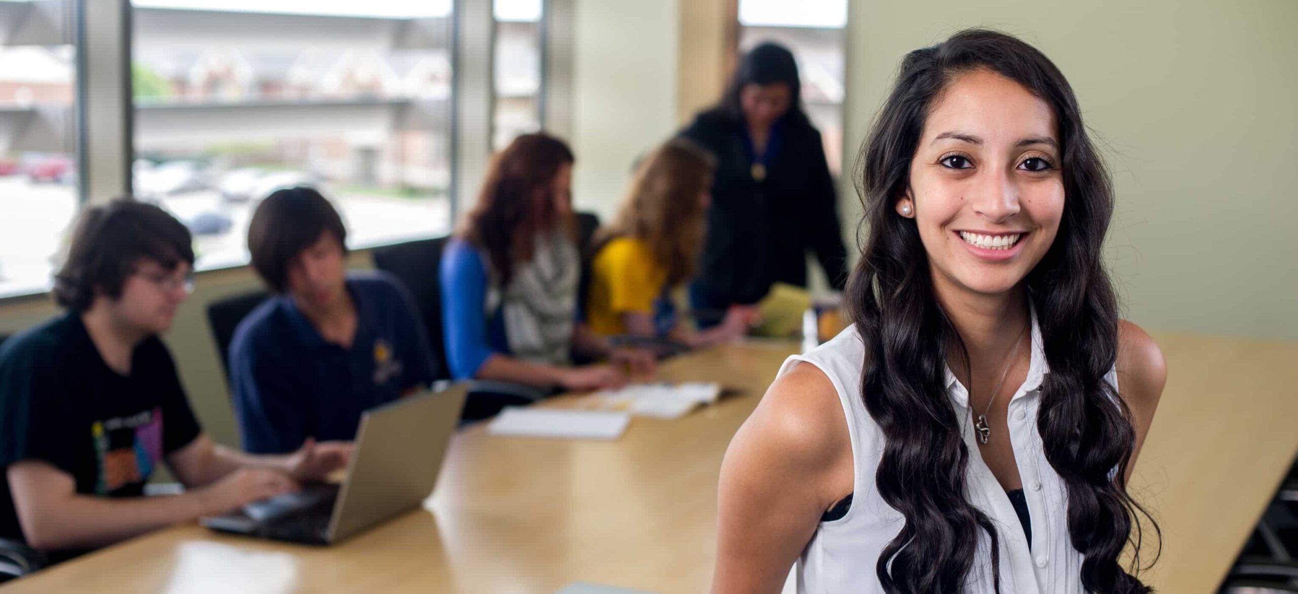 Business student smiling in front of classmates