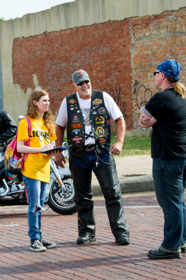 Woman interviewing two bikers
