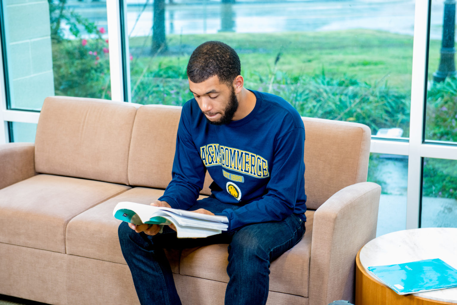 Student reading out of a textbook. 