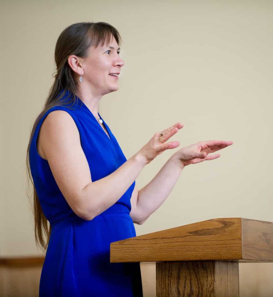 Woman giving a speech at a podium.