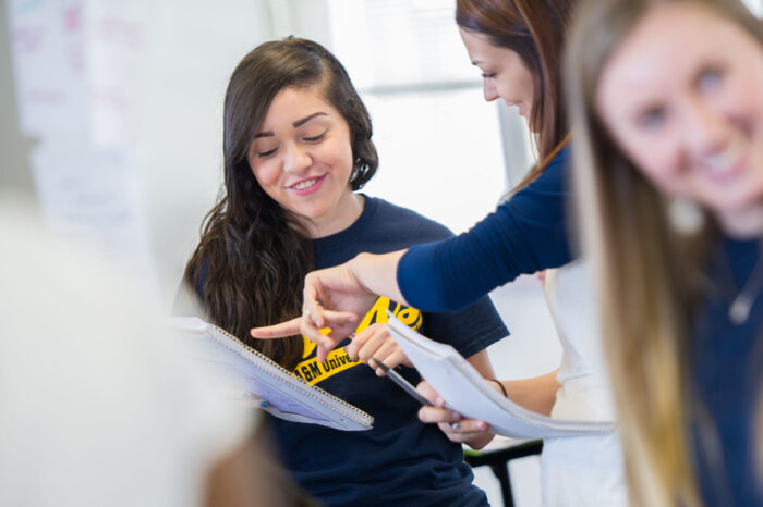 two females working with tablet in class.