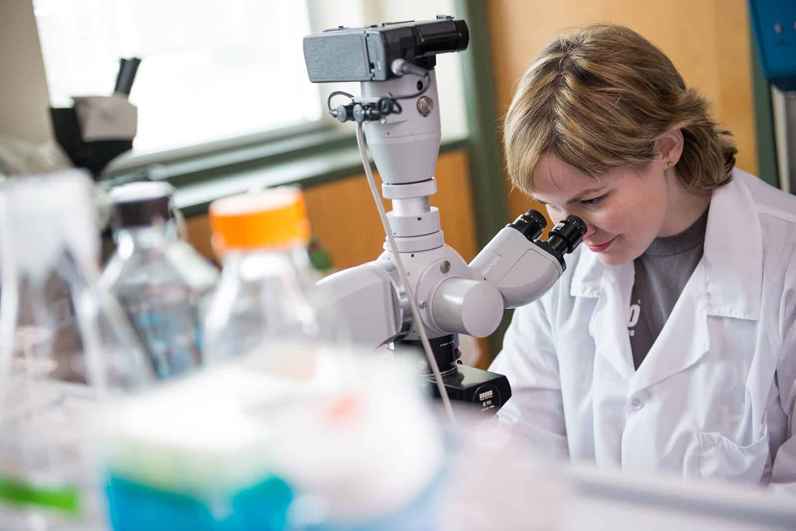 Student preforming lab experiment with a microscope.