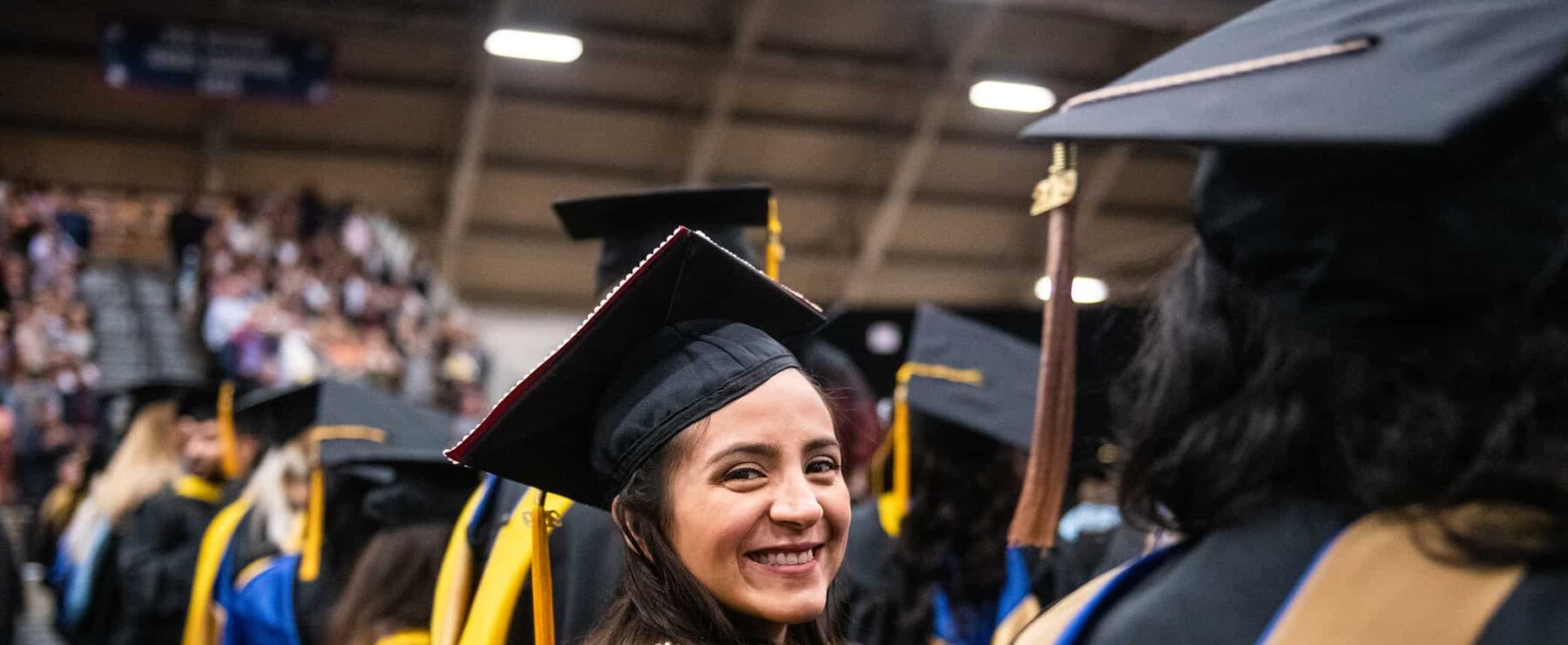 Graduate student smiling at the camera during graduation.