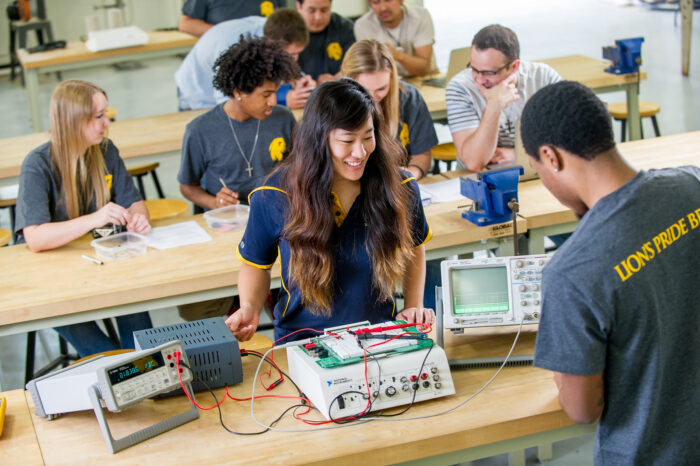 Science and Engineering students working on a circuit board.