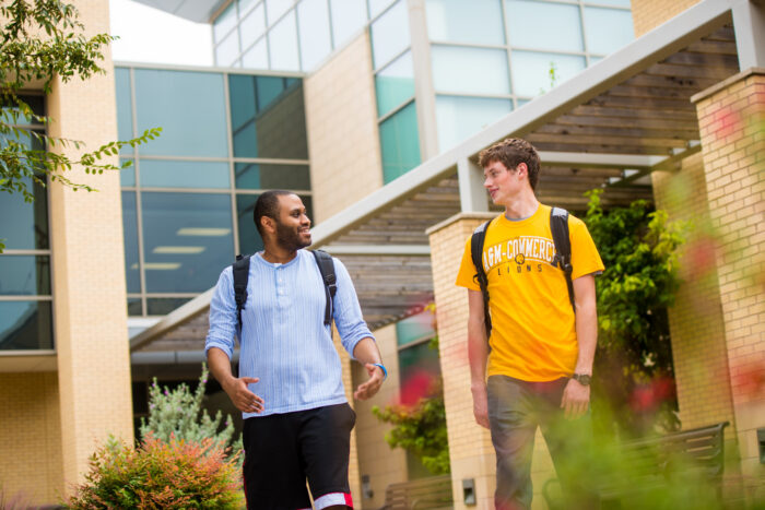 Two students talking and walking.