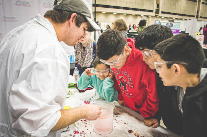 Students engaged in a science experiment that is being instructed by the instructor.