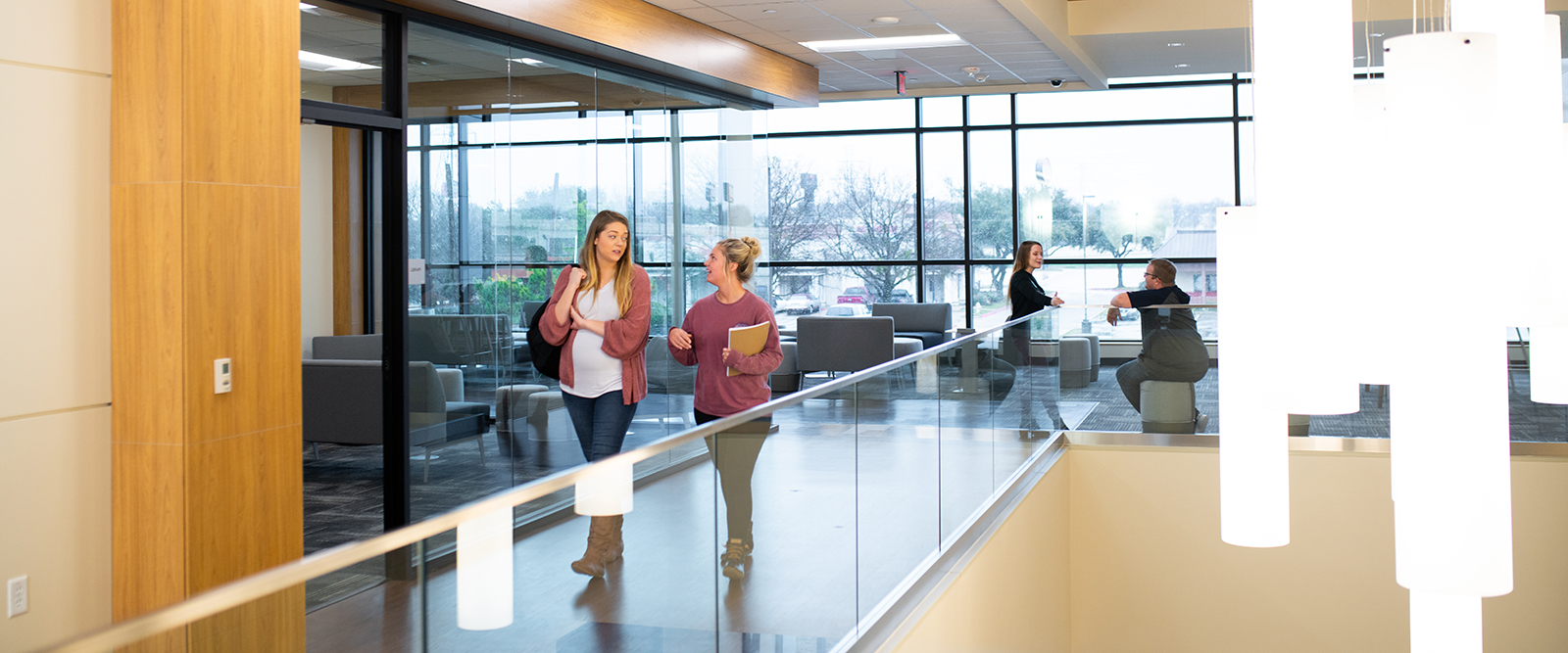 Two female students walking and talking inside the Mesquite Metroplex Center.