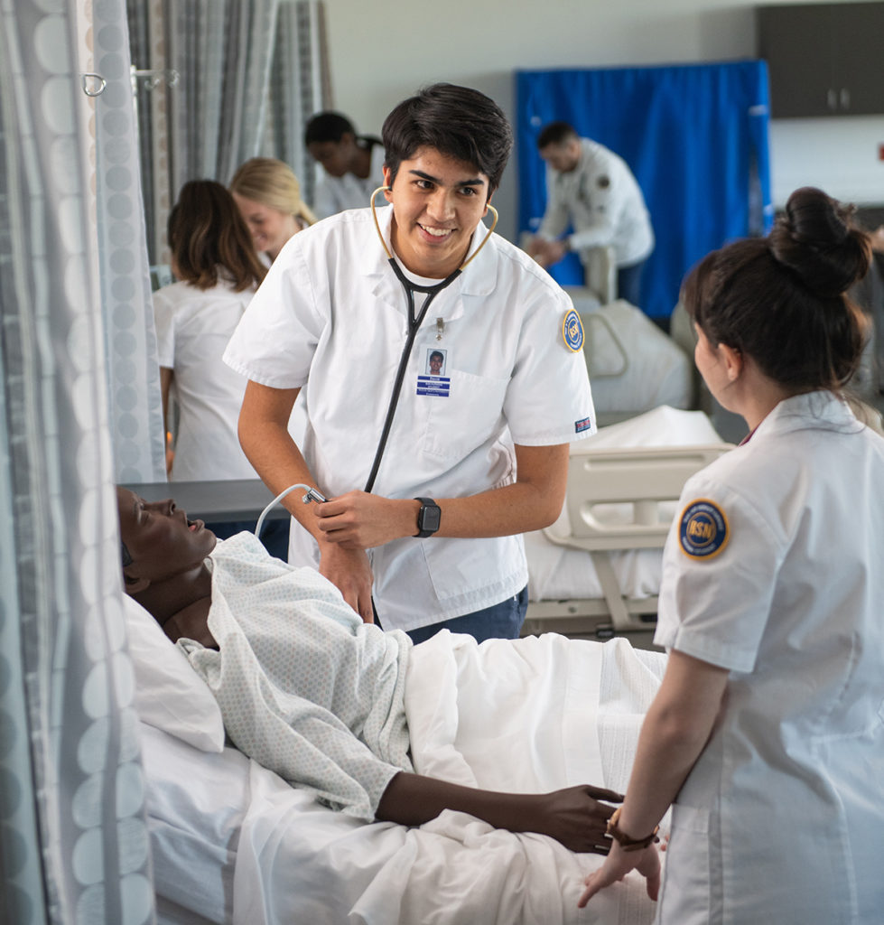 Two nursing students getting hand-on experience in the simulation lab.