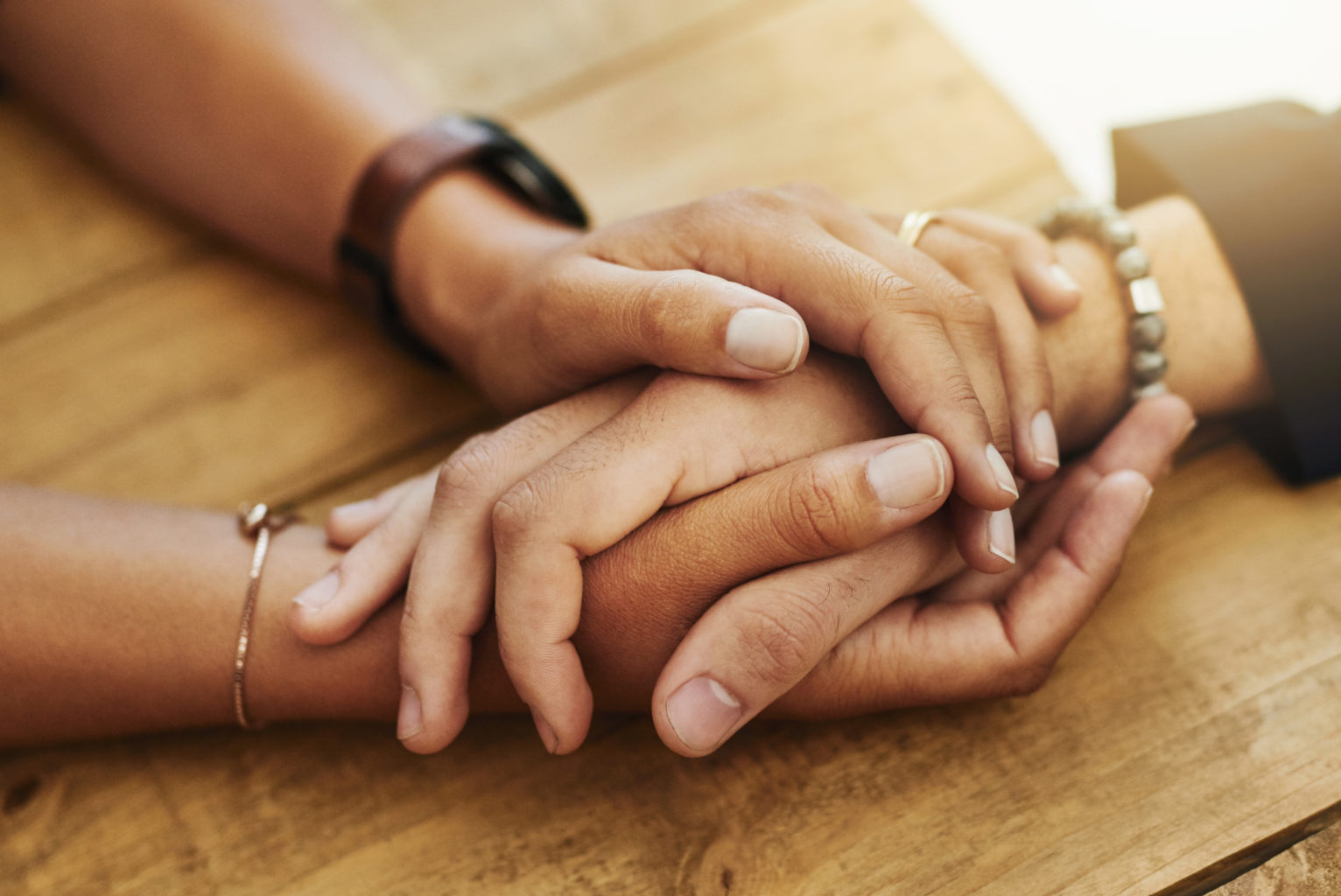 Two pairs of hands holding each other.