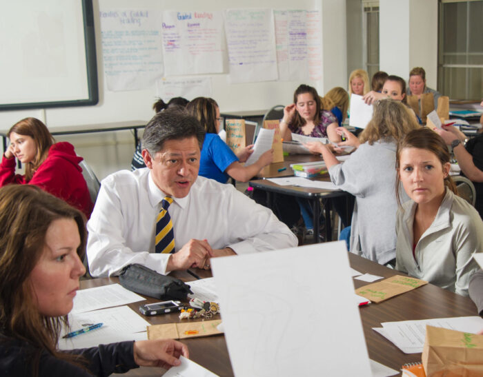 Faculty speaking with students in active learning classroom