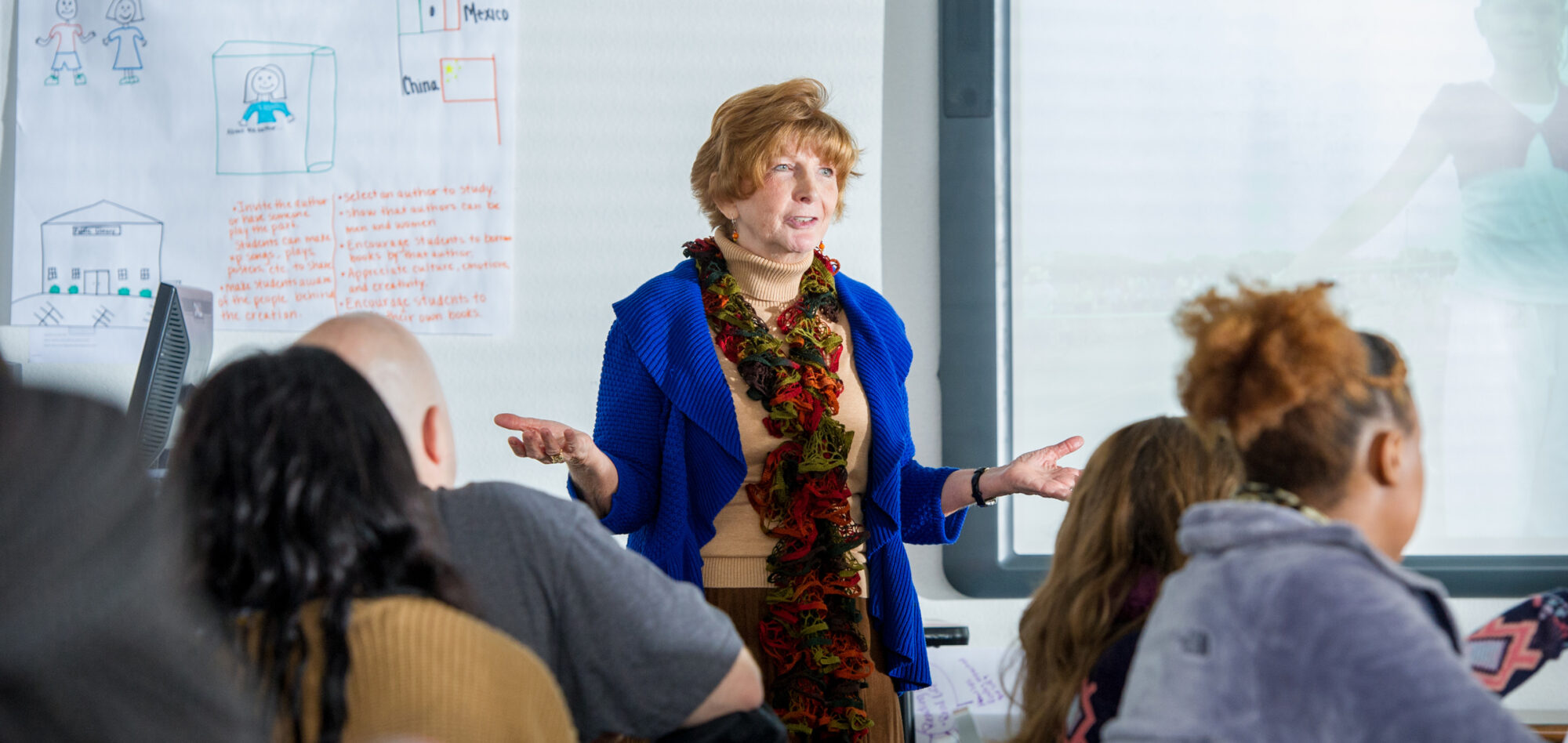 Woman teaching classroom full of college students