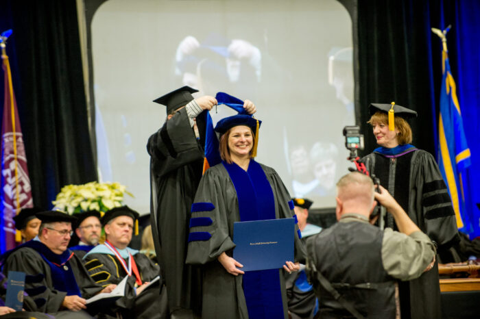 Woman receiving honors during a graduation ceremony.