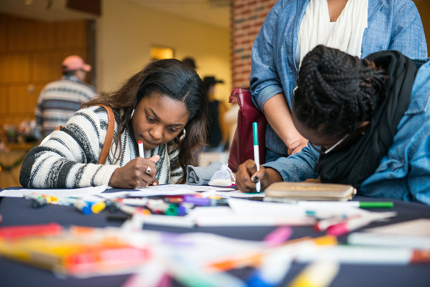 Two students coloring siting at a table.