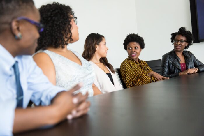 A group of consolers having a conversation siting down at a table.