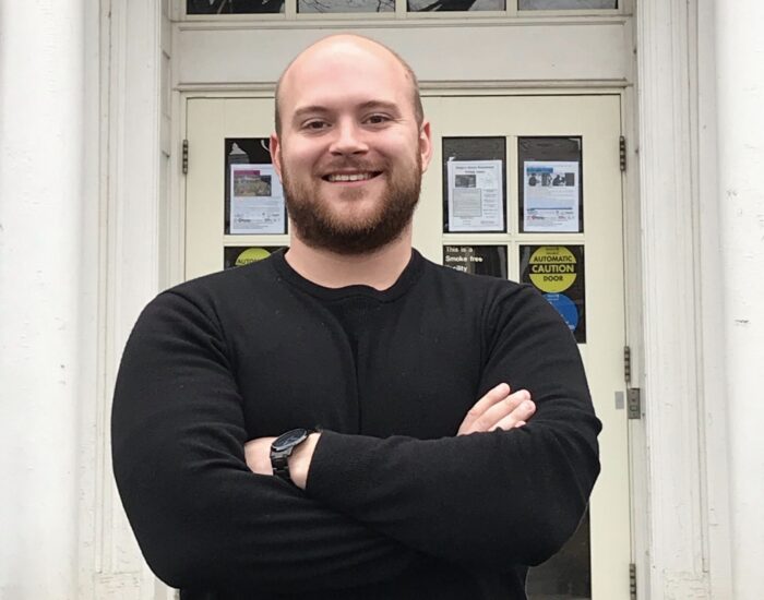 Picture of Nick Sprenger smiling with his arm crossed.