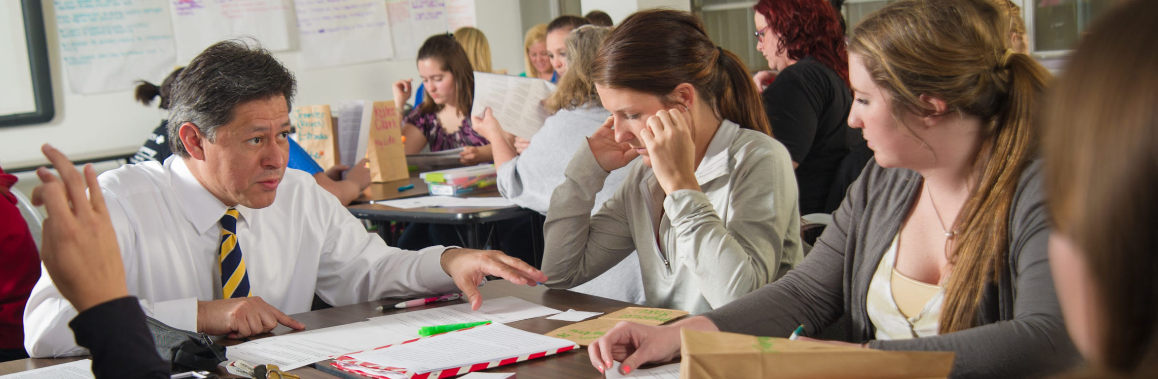 Instructor sitting at table with students.