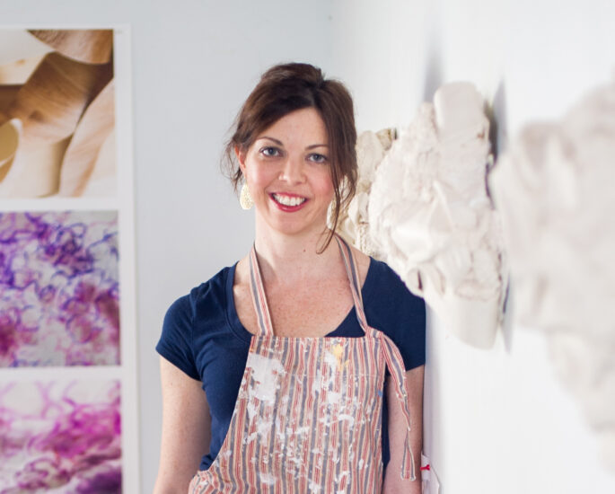 Josie Durkin art professor standing in front of ceramic art.