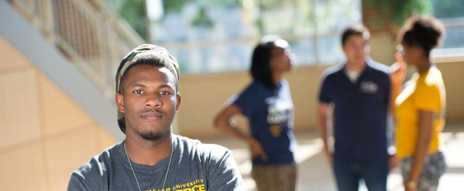 Student wearing a TAMUC shirt on campus.