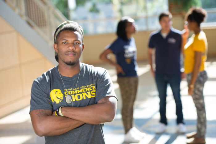 Student wearing a TAMUC shirt on campus.