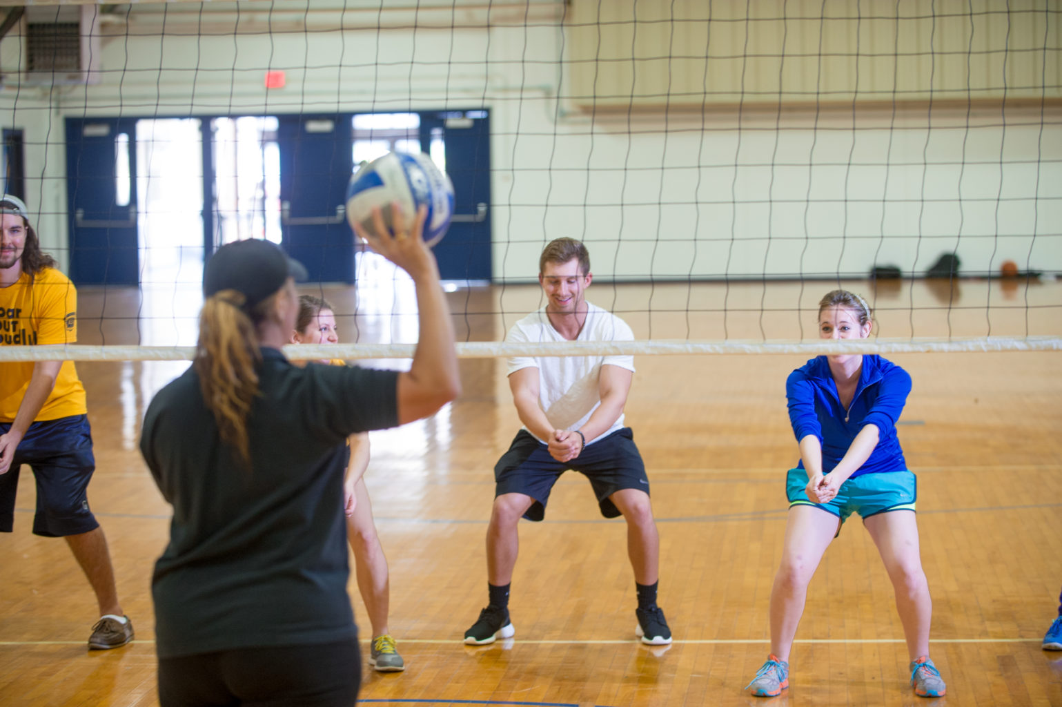 Student learning volleyball inside the Gym in the Commerce campus.