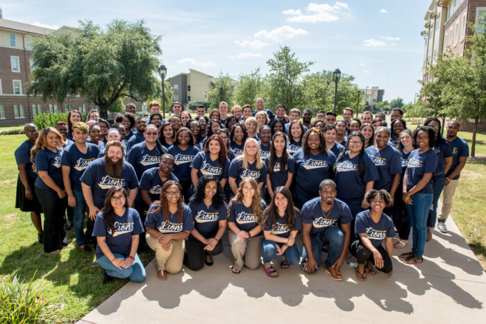 A group photo of TAMUC students wearing the same TAMUC blue shirt.