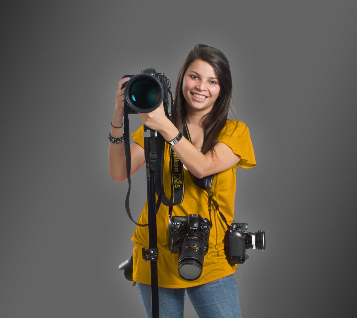 Young woman holding multiple cameras.