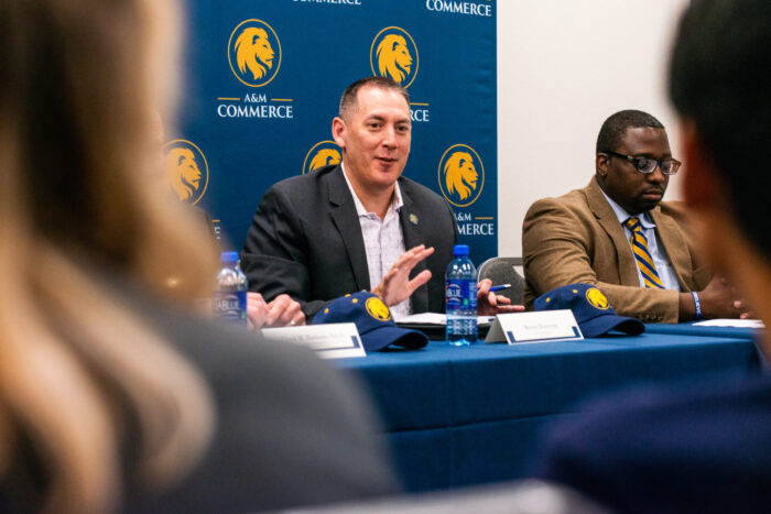 TAMUC Alumni talking to current students during an event.