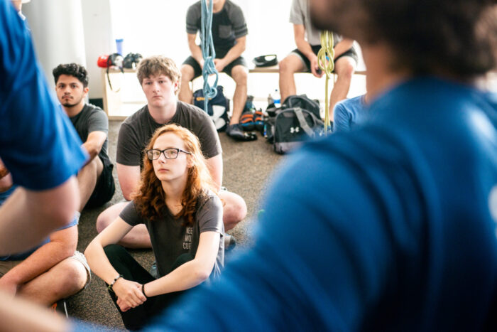 Group of students sitting down listening to professors.