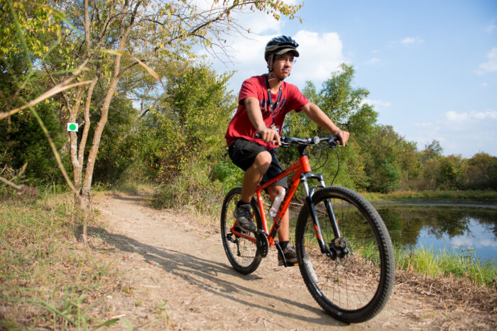 Student on a bike at the Campus Rec Trail.