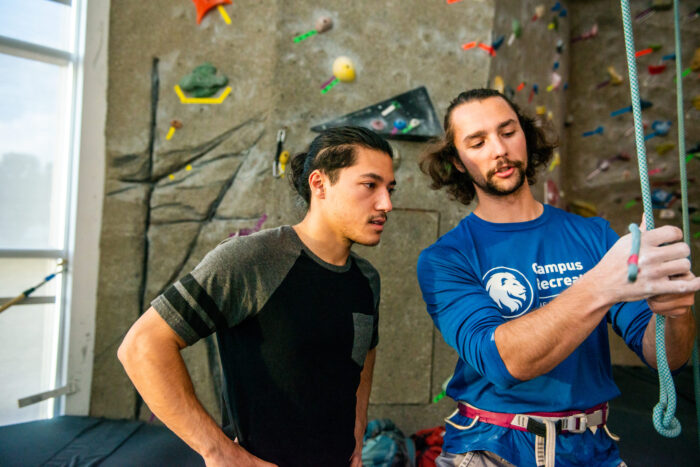 Rock climber instructing a student.