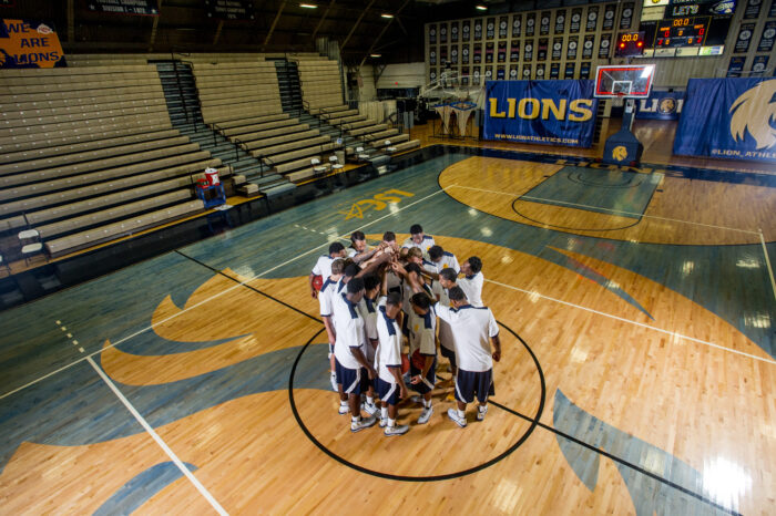 basketball team huddled around mid-court in practice.