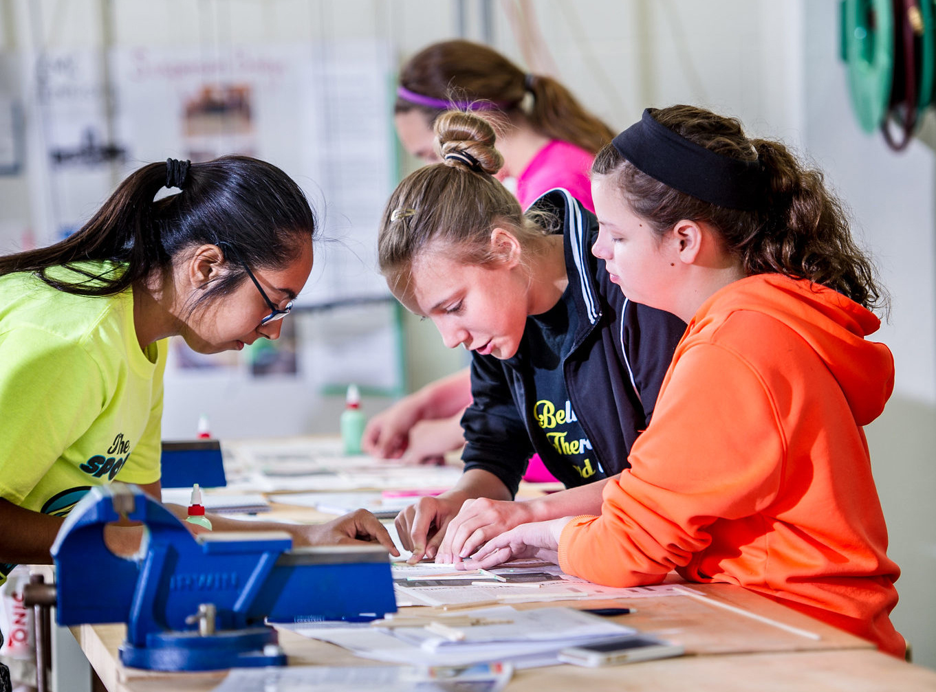 A teacher instructing two middle school students.