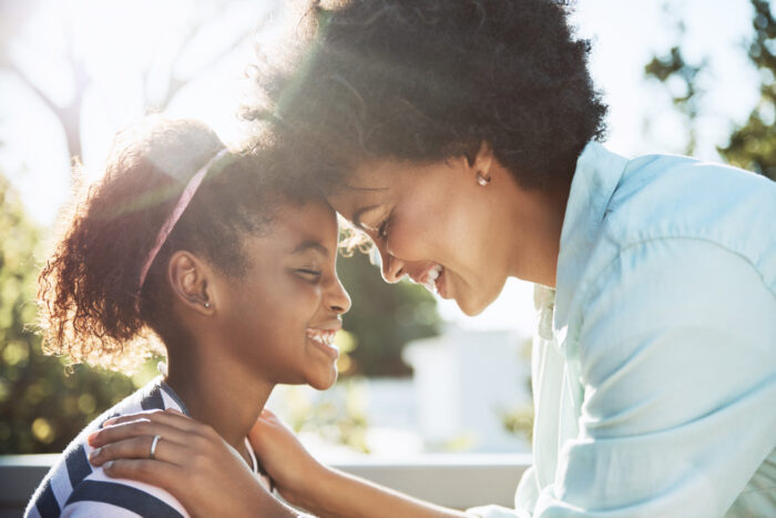 Shot of a cheerful young mother and her daughter putting their heads together while keeping their eyes closed.