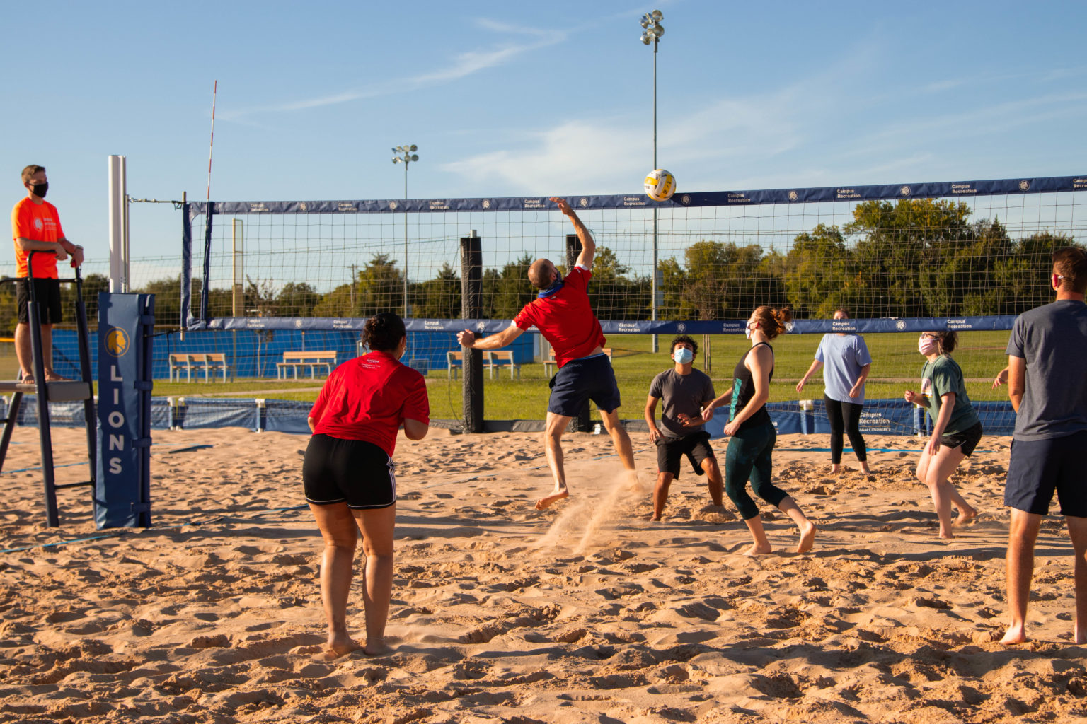 A group of people playing sand volleyball at the Cain Sports Complex.