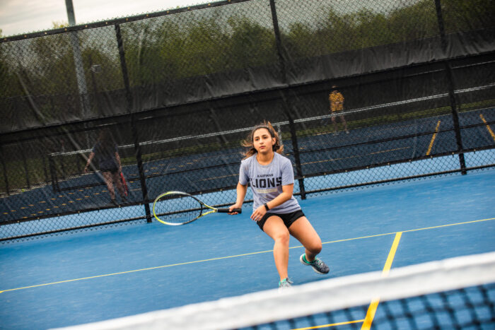 A student playing tennis.