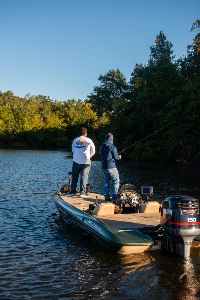 Two students on a boat fishing.