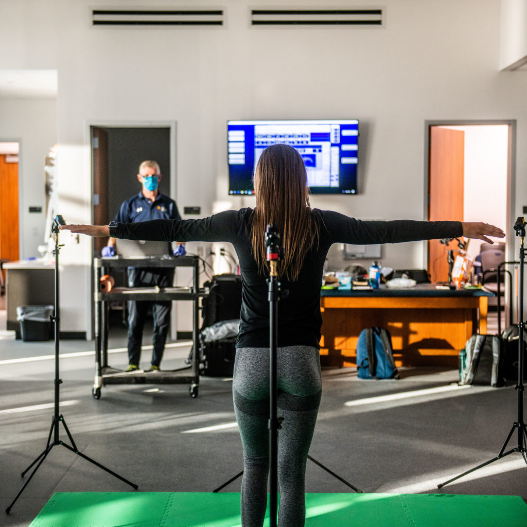 A student during a health science test standing with arms open 90 degrees from her body.