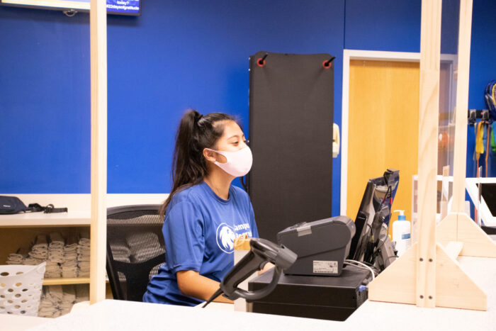 Campus Recreation employee behind the desk wearing a mask.