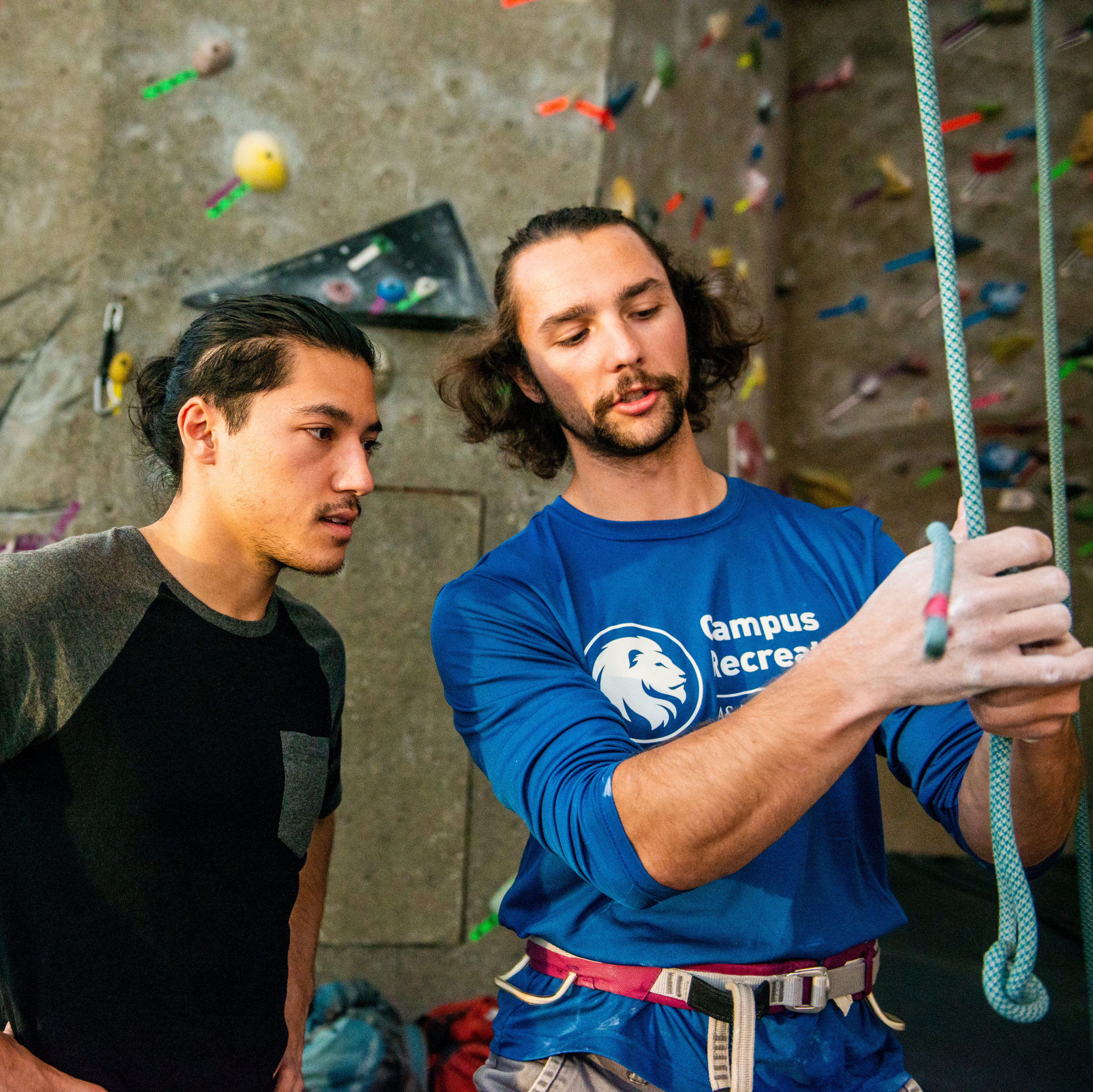 Rock climber instructing a student.