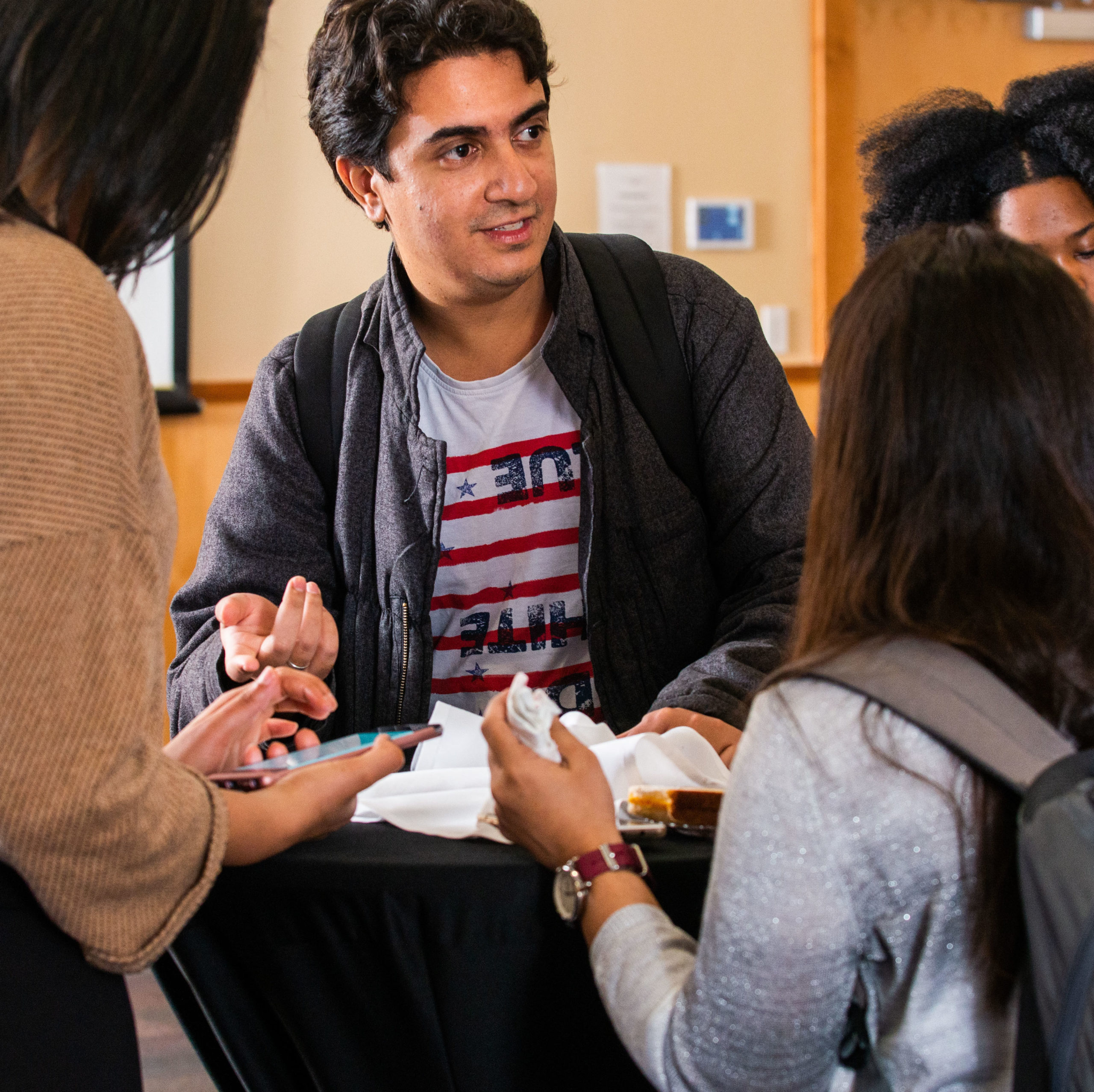 Students having a conversation around a table.